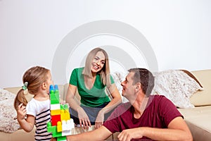 Family is having fun playing with cute girl at home