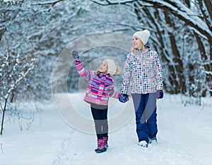 Family having fun, playing and laughing on snowy winter walk in nature.