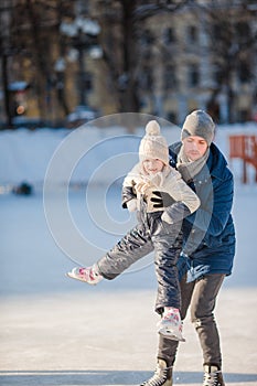 Family having fun on skating rink outdoors