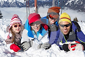 Familia divirtiéndose sobre el esquiar día festivo en montanas 