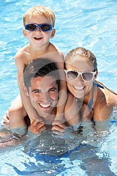 Family Having Fun In Swimming Pool