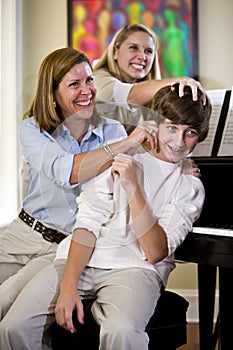 Family having fun teasing teenage boy at home photo