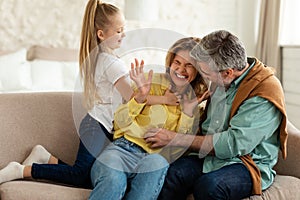 Family Having Fun Tickling And Cuddling Sitting At Home