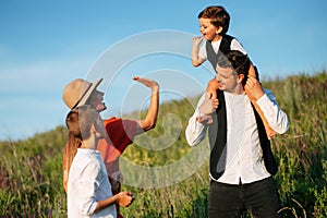 Family having fun walking on field and laughing