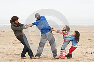 Family Having Fun On Winter Beach