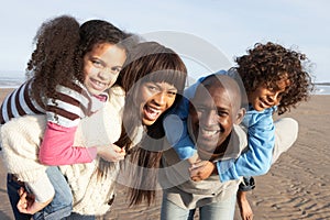 Family Having Fun On Winter Beach