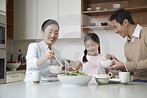 Family Having meal With Chopsticks In Kitchen