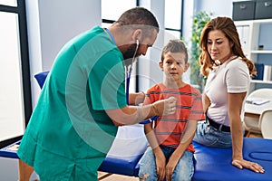 Family having medical consultation auscultating heart at clinic
