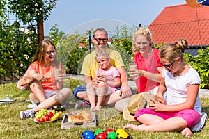 Family having picnic in garden front of their home