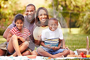 Family Having Picnic In Garden Together