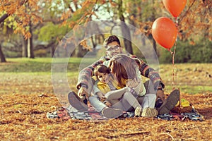 Family having picnic in the park on autumn day