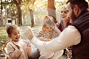 Family having picnic together in park.