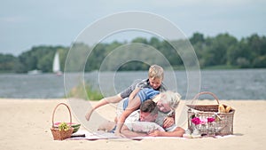 Family Having Piggyback Fun On Beach Holiday