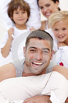 Family having a pillow fight in bed