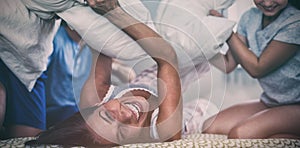 Family having pillow fight in bedroom