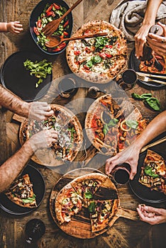 Family having pizza dinner party with red wine, top view