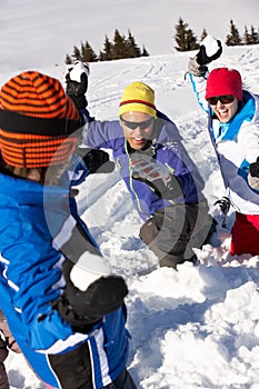 Family Having Snowball Fight On Ski Holiday