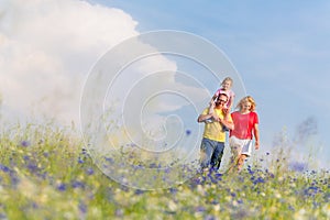 Family having walk on meadow with flowers