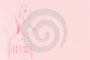 Family hearth - paper house with flying hearts on soft pink color background. Copy space. Valentine day concept for design.