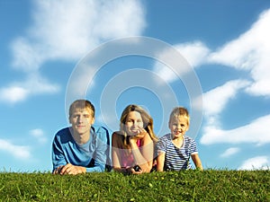 Family on herb under blue sky