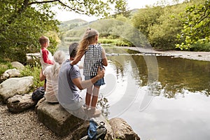 Family On Hike Looking Out Over River In UK Lake District