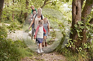 Family Hiking Along Path By River In UK Lake District photo