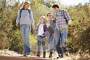Family Hiking In Countryside Wearing Backpacks photo