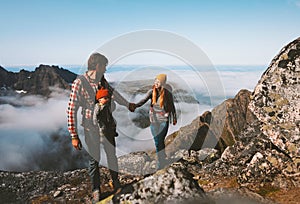 Family hiking man and woman traveling with baby carrier outdoor healthy lifestyle vacations in mountains
