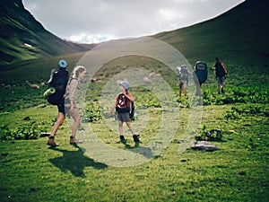 Family hiking in the mountains. A young happy mother and her son take a hike together in the mountains on a beautiful