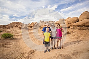 Family hiking together among desert red rock formations at Goblin Valley