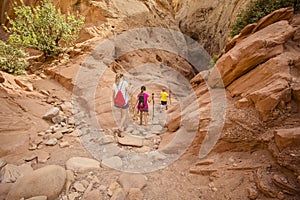 Family hiking together in a sandstone slot canyon near Arches National Park