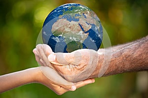 Family holding Earth planet in hands