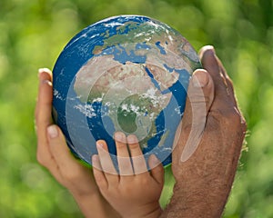 Family holding Earth planet in hands