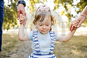 Family holding hands, adopted child being supported by loving parents