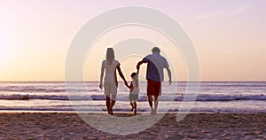 Family, holding hands and beach vacation of a mother, dad and child by the ocean at sunset. Summer, back silhouette and