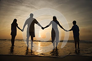 Rodina držení ruky na pláž sledování západ slunce 