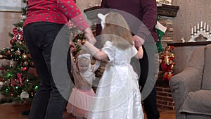 Family holding hands in a circle dance for Christmas. Grandparents and granddaughters celebrate new year 4k