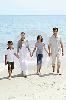 Family holding hands while walking on the beach. Conceptual image