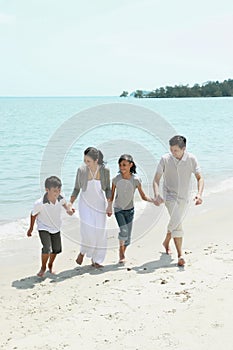 Family holding hands while walking on the beach. Conceptual image