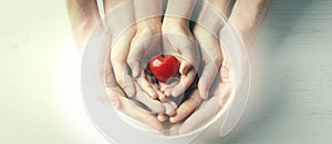 Family holding small red heart in hands on background, top view. Banner design