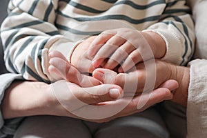 Family holding their hands together, closeup view