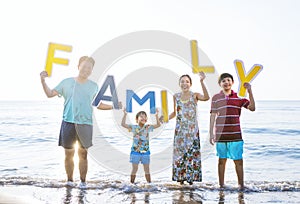 Family holding up letters at the beach