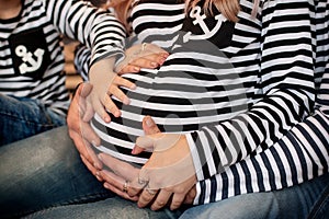 The family holds hands to the tummy of a pregnant mother. Famili bow. Hands. Pregnancy. Waiting.