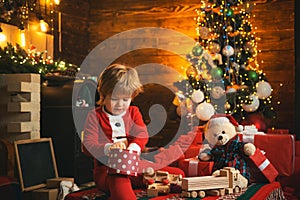 Family holiday. Childhood memories. Santa boy celebrate christmas at home. Boy child play near christmas tree. Merry and