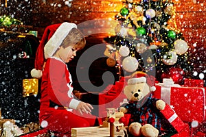 Family holiday. Childhood memories. Santa boy little child celebrate christmas. Boy child play near christmas tree. New