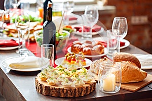 Family holiday festive table setting with healthy sandwiches, bread and appetizers