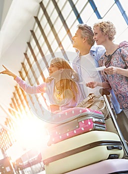 Family on holiday looking at their flights on monitor in airport