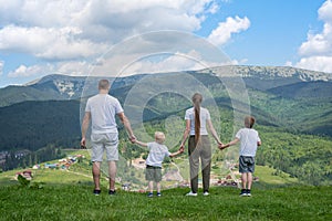 Family holiday. Parents and two sons admire views of the valley.