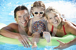 Family On Holiday In Swimming Pool