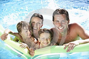 Family On Holiday In Swimming Pool